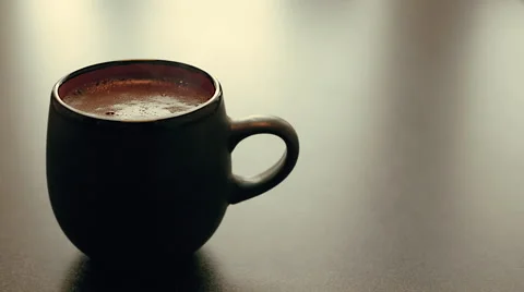 Steaming and aromatic cup of hot black coffee on the table with beautiful light Stock Footage 62086320