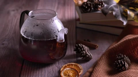 Steaming black tea in a glass teapot on wood Stock Footage 343682986