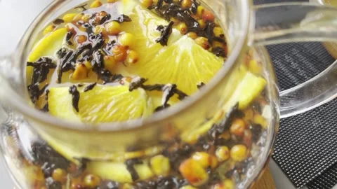 Steaming black tea infuser with honey, orange slices Stock Footage 304879583