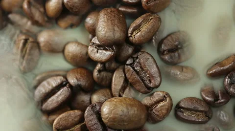 Steaming coffee beans fall in a heap close-up Stock Footage 56708938