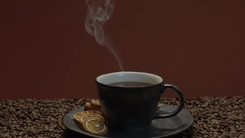 Steaming coffee cup on beans with dried citrus Stock Footage 339685838