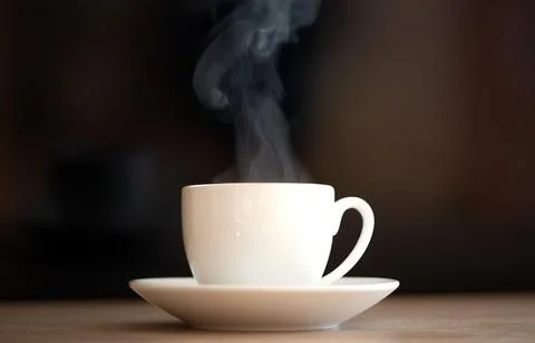 A steaming coffee cup placed on a rustic wooden table truly a delightful mo.. Stock Photos