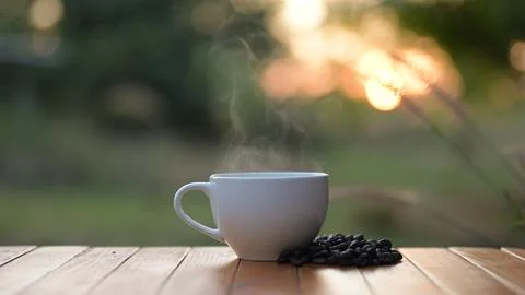 Steaming Coffee Cup Surrounded by Coffee Beans Outdoor Setting Natural Light Stock Photos