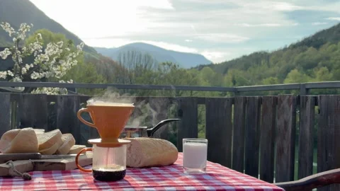 Steaming coffee with fresh bread on outdoor terrace table 動画素材 333525841
