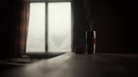 Steaming coffee or tea in a thermo cup on texture table. Dark atmosphere Stock Footage 122578489