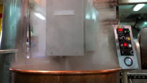 Steaming copper cauldron preparing chocolate for chocolate factory Stock Footage 108497748