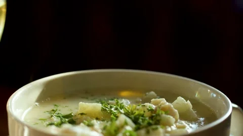 Steaming Creamy Chowder in White Bowl with Wine Glass Stock Footage 318635475