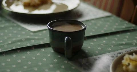 Steaming cup of coffee by breakfast plates Stock Footage 252750477