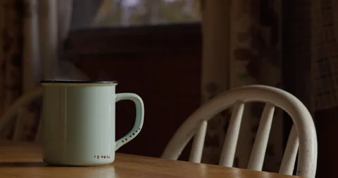 Steaming Cup of Coffee inside of a warm cabin 库存影片 141943732