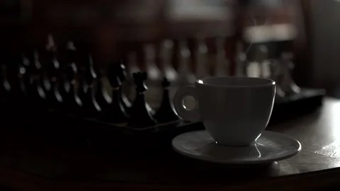 Steaming Cup of coffee or tea near the chessboard Stock Footage 143189523