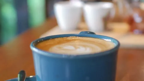 Steaming Cup of Hot Coffee standing on Table at coffee shop. Stock Footage 334648874