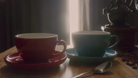 Steaming Cups of coffee or tea. Coffee cup and beans. A red and blue cup of Stock Footage 232997438