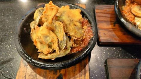 Steaming dumplings rest in a rustic stone bowl Stockfoto's