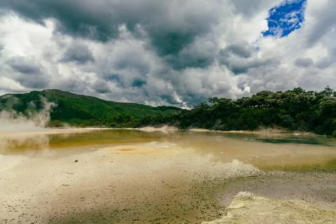 Steaming Geothermal Lake Under Dramatic Storm Clouds 写真素材