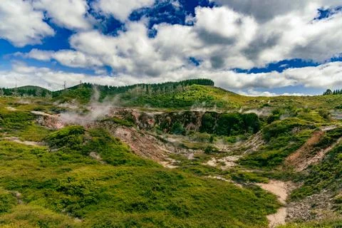 Steaming Geothermal Valley Under Dramatic Cloudy Sky 스톡 사진