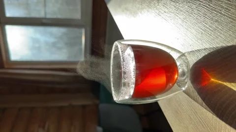 A steaming glass of tea sits on the kitchen Stock Footage 302813333