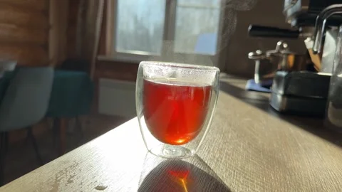A steaming glass of tea sits on the kitchen Stock Footage 302813368