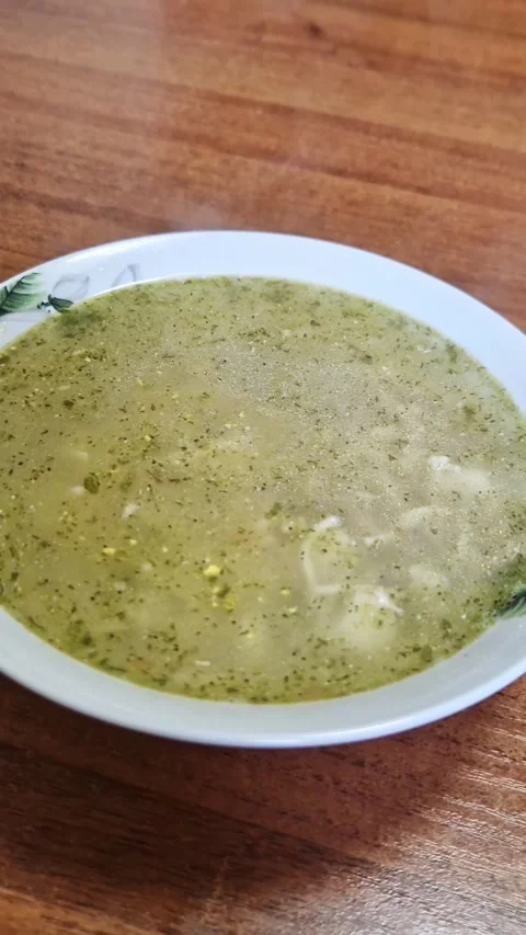 Steaming Green Vegetable Soup in White Patterned Bowl Stock Footage 323524736