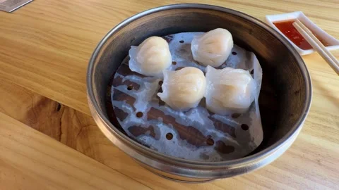 Steaming har gow shrimp dumplings in bamboo basket on wooden table Stock Footage 346087018