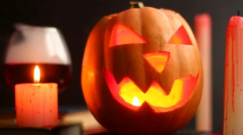 Steaming head Halloween Jack pumpkin on the table near a glass with smoke Stock Footage 68417005