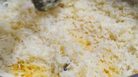 Steaming Hot Biryani Rice Being Stirred in a Traditional Cooking Pot Stock Footage 320442041
