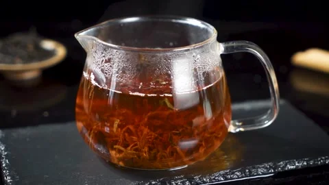 Steaming Hot Black Tea in Glass Pitcher on Dark Stone Tray Stock Footage 341926133