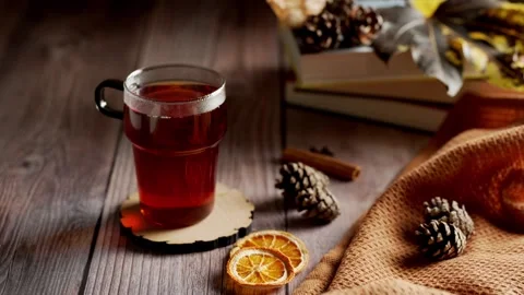 Steaming hot black tea in a glass with autumn decor Stock Footage 343766955