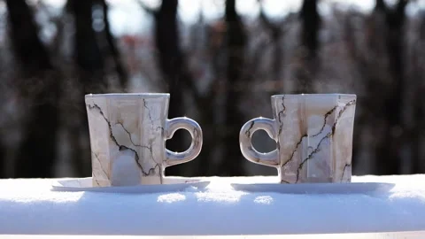 Steaming Hot Coffee Cups on Snow Near Forest on Sunny Winter Day EU Stock Footage 327041173