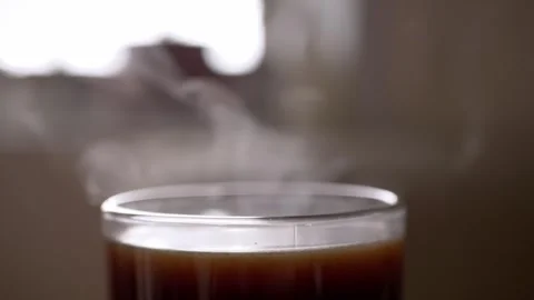 Steaming Hot Coffee in Glass Cup on Table with Cozy Warmth and Invigorating Stock-Footage 339067904