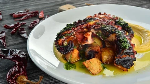 Steaming hot grilled octopus is the best served with fried potatos. 4k Stock Footage 148798069