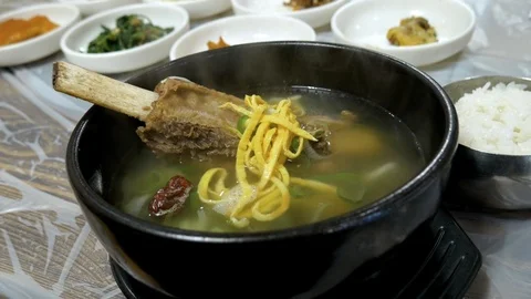 Steaming hot Korean beef bone soup (galbitang) in a rock bowl. Video stock 104998153