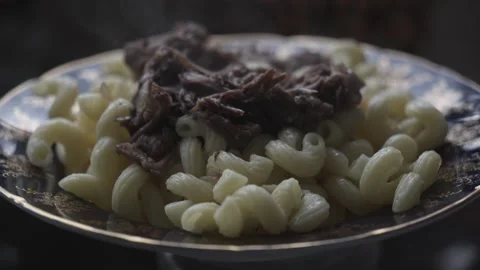Steaming hot pasta with stewed beef on a plate, close-up 4K Stockbeeldmateriaal 330798807