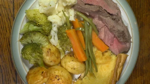 A steaming hot plate of roast beef, vegetables and Yorkshire pudding. Video stock 255022579