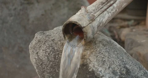 Steaming hot spring onsen water running from a pipe in a bamboo tube Video stock 108626150