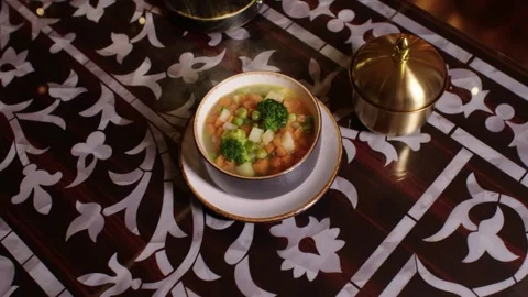 Steaming hot vegetable soup on a traditional ornate Arabic table in a restaurant Stock Footage 345134256