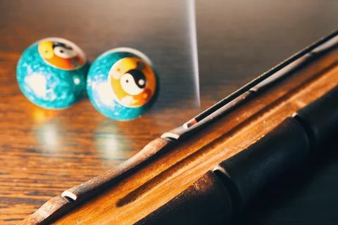 Steaming incense stick and baoding balls on the table Stock Photos