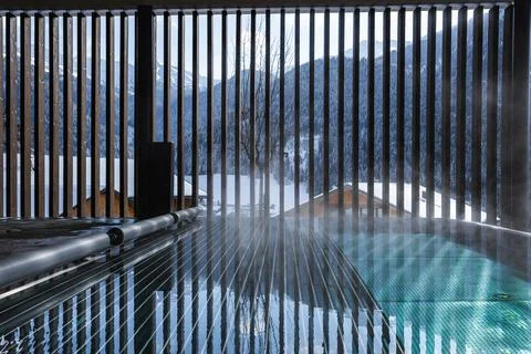 Steaming infinity pool and vertical slats at Dolomites mountain spa Stock Photos