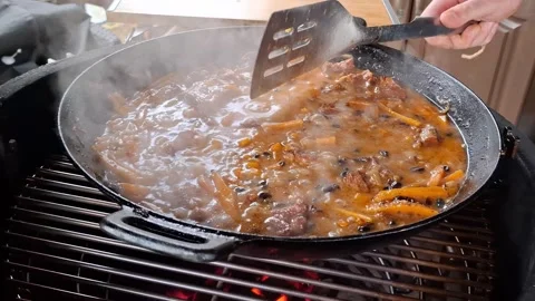 Steaming meat and vegetable stew cooking on outdoor grill Stock Footage 334724339