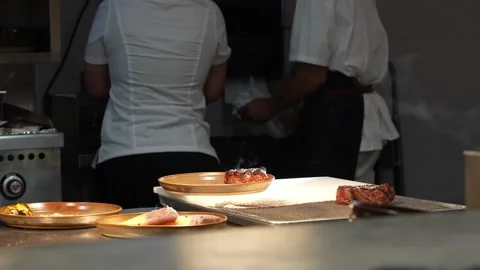 Steaming meat being plated in the kitchen of a fancy restaurant Stock Footage 284228736