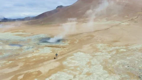 Steaming mud pool with blue orange color in hverir, Iceland, tilt reveal Stock Footage 138737645