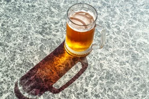 A steaming mug of beer on the table Stock Photos