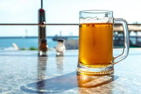 A steaming mug of beer on the table Stock Photos