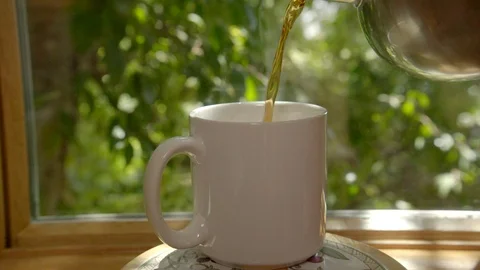 A steaming mug of coffee or tea in morning sunshine Stock Footage 94928300