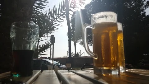 A steaming mug of cold beer on the table of a summer cafe in the southern city. Stock Footage 125129556