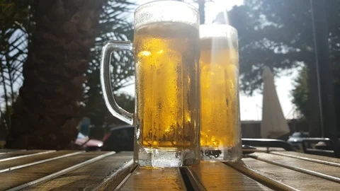 A steaming mug of cold beer on the table of a summer cafe in the southern city. Stock Footage 125129635
