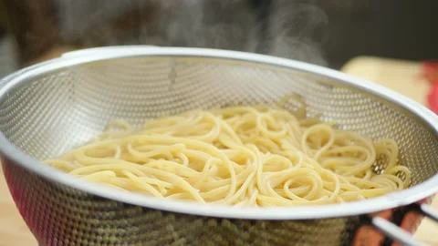 Steaming pasta draining in a colander closeup Video stock 143163191