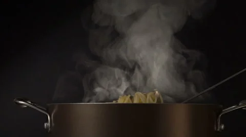 Steaming pasta in a spaghetti spoon on black background Stock Footage 62289569