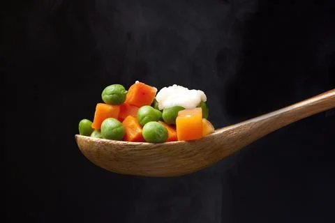 Steaming peas and carrots. Stock Photos