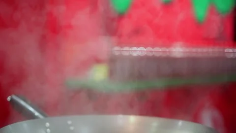 A steaming pot is placed against a vibrant and colorful background, enhancing Stock Footage 291016325