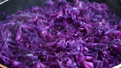 Steaming purple cabbage cooking in pan releasing vibrant aroma Stock Footage 331576673